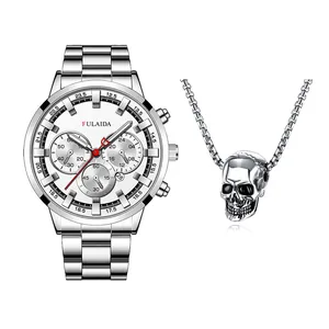Detail van zilveren zakelijk horloge met lichtgevende wijzers en bijpassende schedelketting