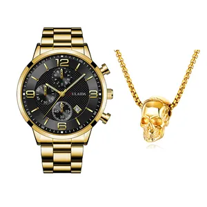 Detail van gouden herenhorloge met zwarte wijzerplaat en bijpassende schedel hanger set