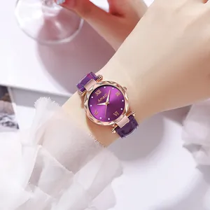 Gros plan d'une montre femme avec cadran violet, boîtier or rose et bracelet en cuir