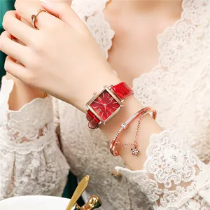 Gros plan sur une montre carrée en or rose avec bracelet en cuir rouge et bracelet étoile