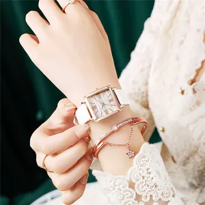 Détail de montre carrée en or rose avec cadran marbré et bracelet à pendentif étoile