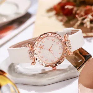 Elegant rose gold women's watch with white floral dial and leather strap on marble
