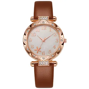 Detail of rose gold watch with sparkling crystals and brown leather strap
