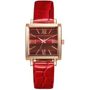 Détail du boîtier carré en or rose avec cadran rouge et bracelet en cuir à motif crocodile