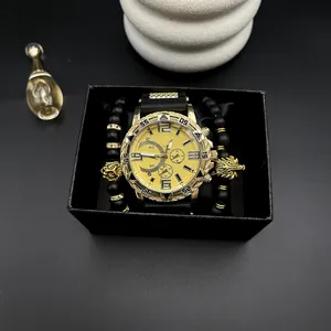 Dettaglio dell'orologio dorato da uomo con cinturino nero e braccialetti in una confezione