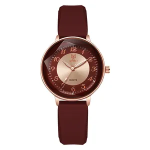 Detailed macro of a women's watch featuring a wine red silicone strap and rose gold case