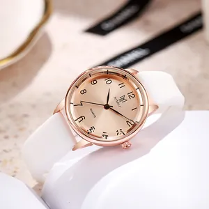 Minimalist quartz watch with rose gold case, white silicone strap, and champagne dial