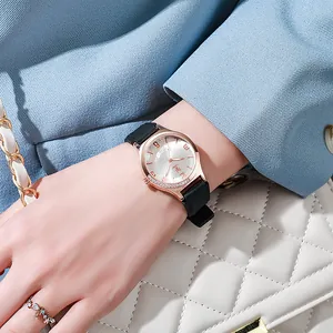 Close-up of rose gold watch dial with crystals and black silicone strap on a female wrist