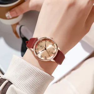 Elegant rose gold quartz watch with a burgundy strap and minimalist Arabic numeral dial