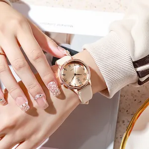 Close-up of minimalist rose gold quartz watch with beige silicone strap on woman wrist