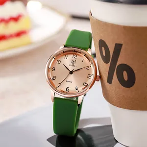 Detail of rose gold quartz watch with vibrant green silicone strap near white coffee cup