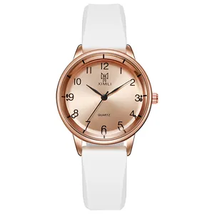 Detail of rose gold quartz watch with white silicone strap and Arabic numeral dial