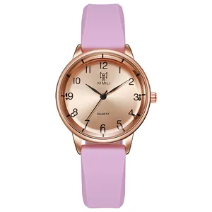 Detail of pink silicone strap quartz watch with rose gold case and gold sunray dial