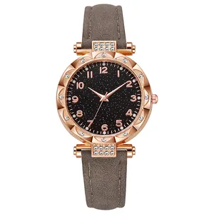 Dettaglio dell'orologio oro rosa con quadrante stellato, ghiera a fiore e cinturino grigio