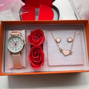 Rosafarbenes Uhrenset mit Herzschmuck und roten Rosen in einer Luxus-Geschenkbox