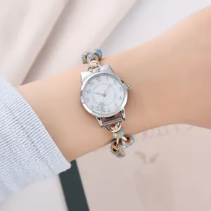 Détail d'une montre chat créative avec perles marbrées bleues et bracelet tissé au poignet