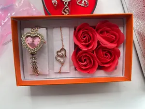 Geschenkset mit roségoldener Herzuhr, Armband und roten Rosen in einer orangefarbenen Box