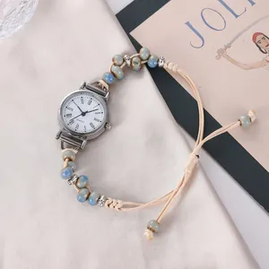Détail du bracelet de montre perle bohème tissé sur un tissu en satin élégant et raffiné