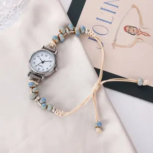 Détail d'une montre à quartz bohème avec bracelet perlé sur fond de soie