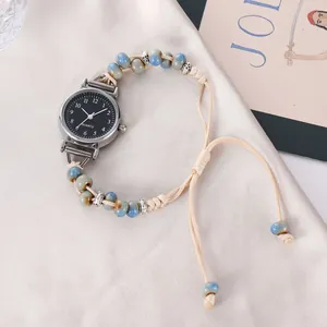 Détail de montre à quartz avec perles en céramique bleue sur fond en soie champagne