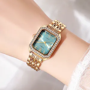 Detail of elegant gold square watch with crystal bezel and blue dial on woman's wrist