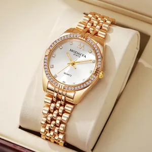 Detailed close-up of golden quartz watch with sparkling rhinestones and metal link band