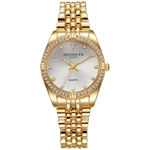 Macro detail of gold watch bezel and white dial encrusted with shimmering rhinestones