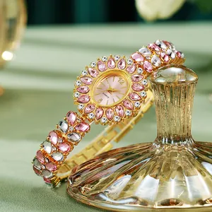 Zoom sur la lunette tournesol en strass rose et le bracelet à bijoux doré de la montre quartz