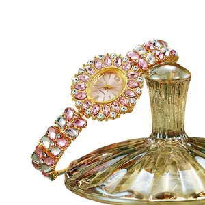 Montre quartz luxe pour femme dorée avec strass roses et design floral de style ethnique