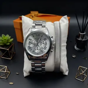 Silver stainless steel couples watch set with Roman numerals on a white velvet pillow