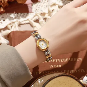 Montre à quartz vintage élégante pour femme avec bracelet chaîne bicolore et cadran cristal