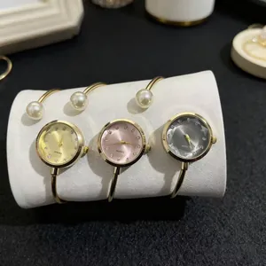 Gros plan de montres bracelets à perles avec cadrans ronds en or, rose et gris