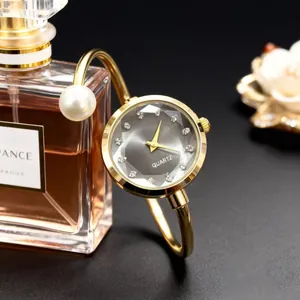 Montre-bracelet à quartz dorée élégante avec perle et cadran gris orné de strass