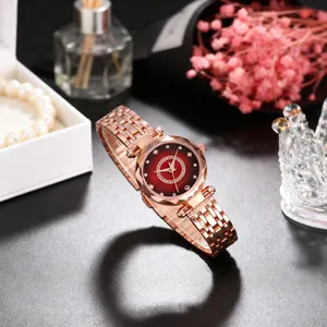 Detail of rose gold ladies watch with red starry dial and rhinestones in elegant setting