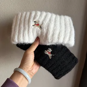 Close-up of knit dog headband with vertical ribbed texture and detailed embroidery