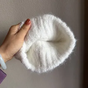 Close-up of white fluffy knit headband showing soft mohair texture and ribbed pattern