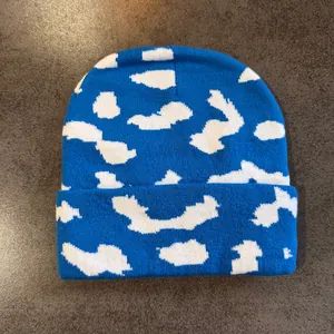Detailaufnahme der dicken blauen Strickstruktur mit weißem Wolken-Jacquard-Muster