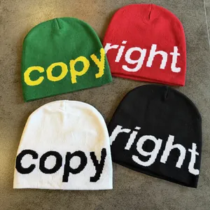 Four knit beanies with jacquard letters in green, red, white, and black colors