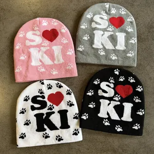 Dettaglio della trama a maglia dei berretti Y2K con motivi a cuore e lettere in quattro colori