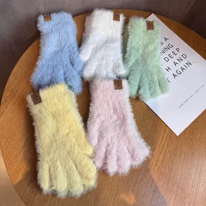 Détail de gants d'hiver en peluche aux couleurs macaron avec logo HL sur table en bois