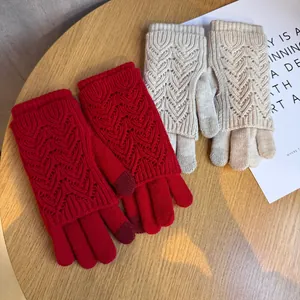 Dettaglio della trama a maglia a cuore e punte touch sugli guanti invernali in maglia