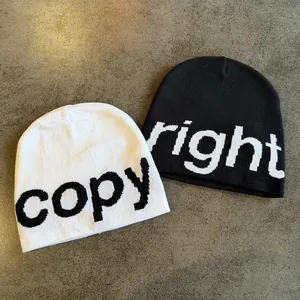 Detail of black and white knitted beanies with jacquard copy and right letter texture