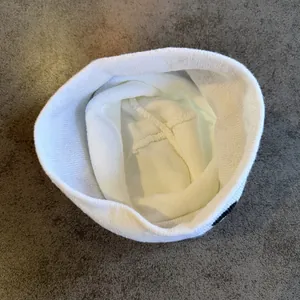 Detailed interior view of white knit beanie showing warm lining and fine stitching work