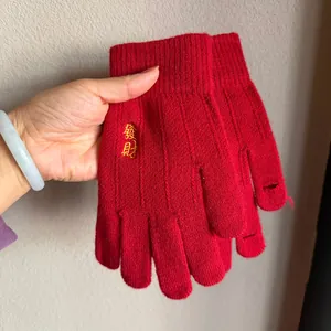 Close-up of red knit gloves featuring golden Chinese embroidery and open finger design
