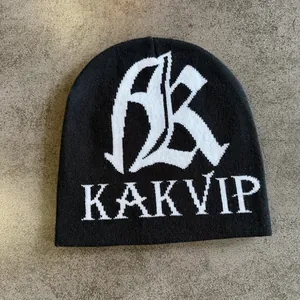 Nahaufnahme der schwarzen Strickmütze mit weißem Jacquard-Logo und Text-Detail