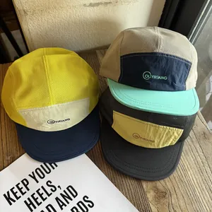 Three multi-colored 5-panel mesh hats with embroidered logo on a wooden table