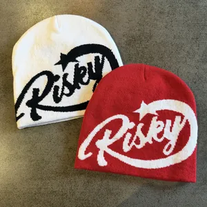 Close-up of jacquard knit beanies in red and white colors with Risky letter patterns
