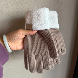 Close-up of thick knitted winter gloves with plush fleece cuffs and leather tag detail