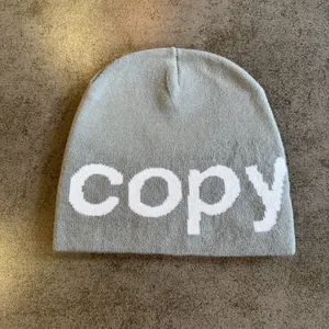 Macro detail of grey knitted beanie featuring white copy text and soft texture