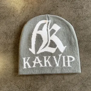 Detailansicht der grauen Strickmütze mit weiß gestickten AK KAKVIP Buchstaben